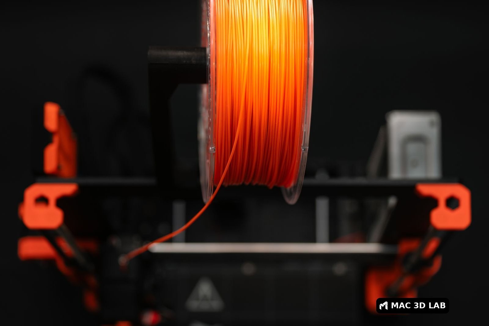 Bobina de filamento naranja en una impresora 3D