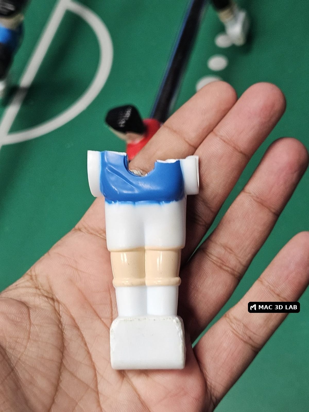 Jugador de futbolín roto, listo para reponer la pieza